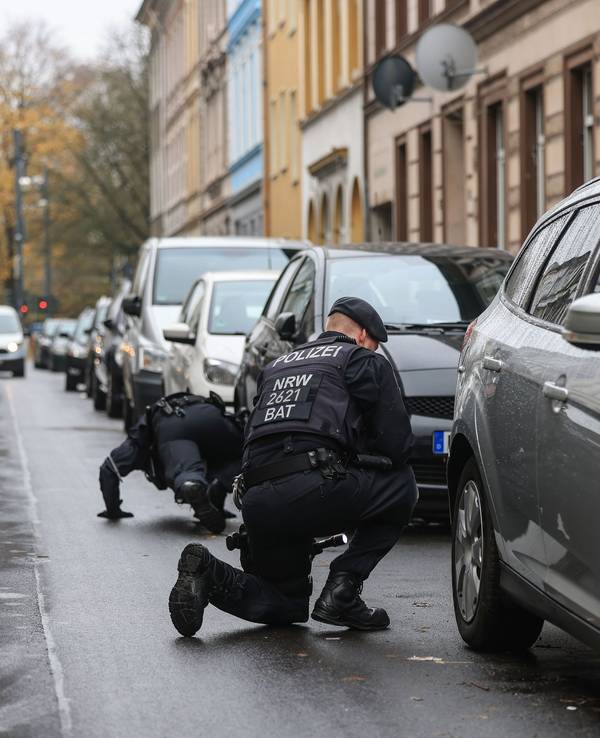 Polizisten suchen in der Nähe eines Tatortes nach Spuren.