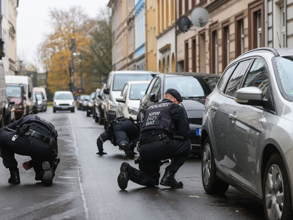Polizisten suchen in der Nähe eines Tatortes nach Spuren.