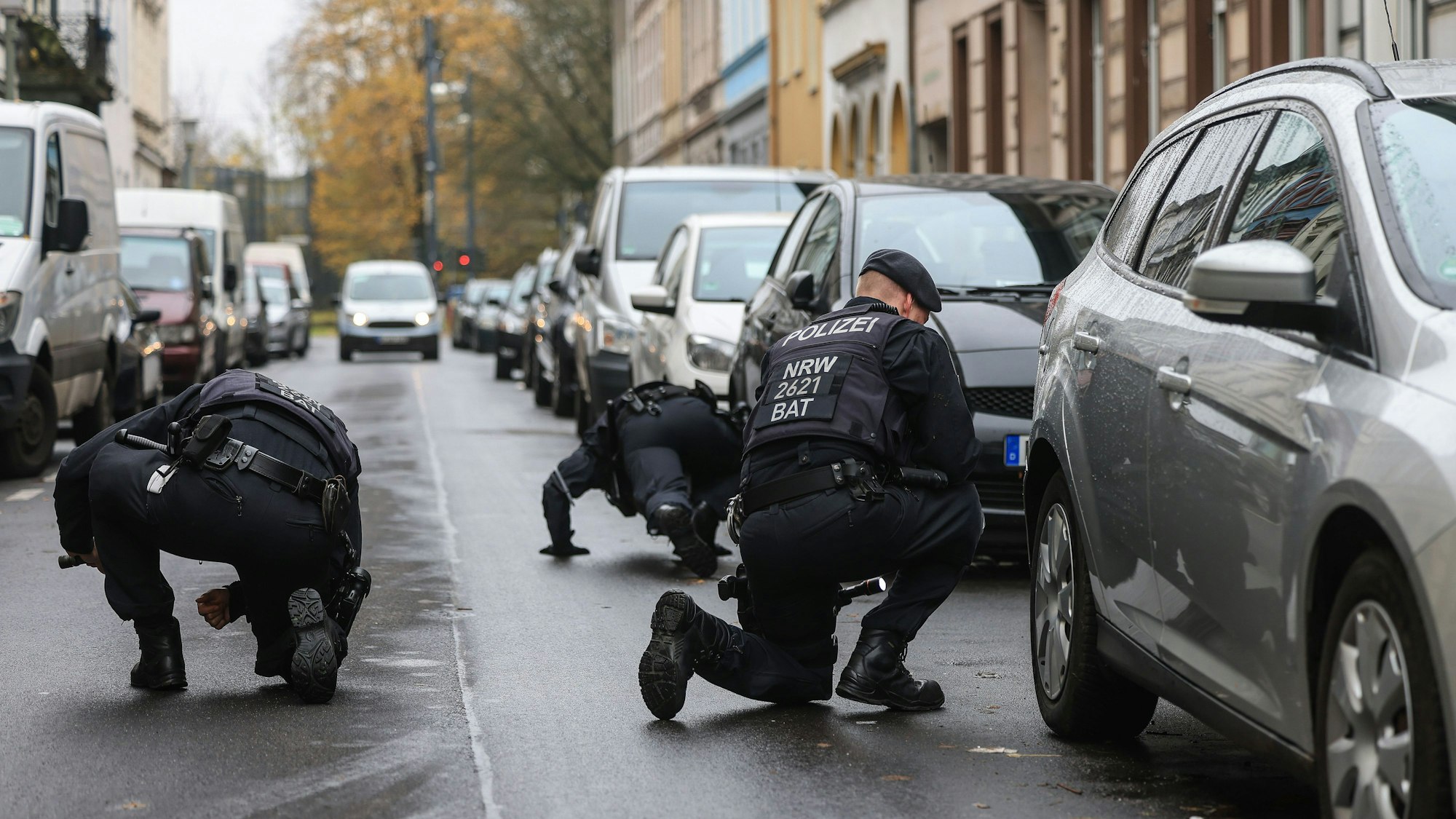 Polizisten suchen in der Nähe eines Tatortes nach Spuren.