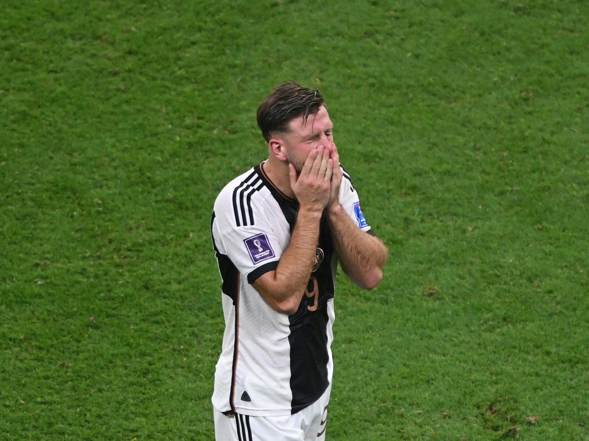 Niclas Füllkrug hält sich nach dem deutschen 4:2-Siegs am 1. Dezember 2022 in Katar die Hände vor das Gesicht. Deutschland ist in der WM-Vorrunde in Katar ausgeschieden.