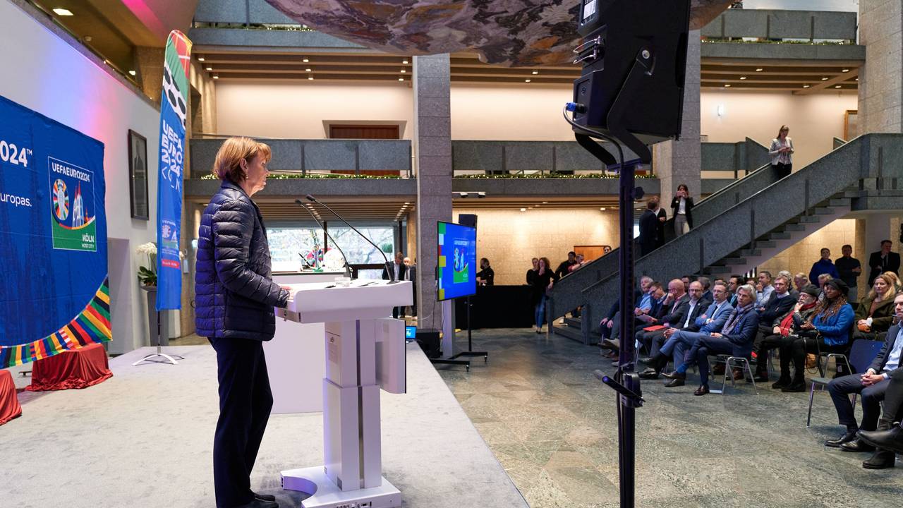 Henriette Reker steht am Rednerpult und hält vor Gästen der UEFA in Köln eine Rede.