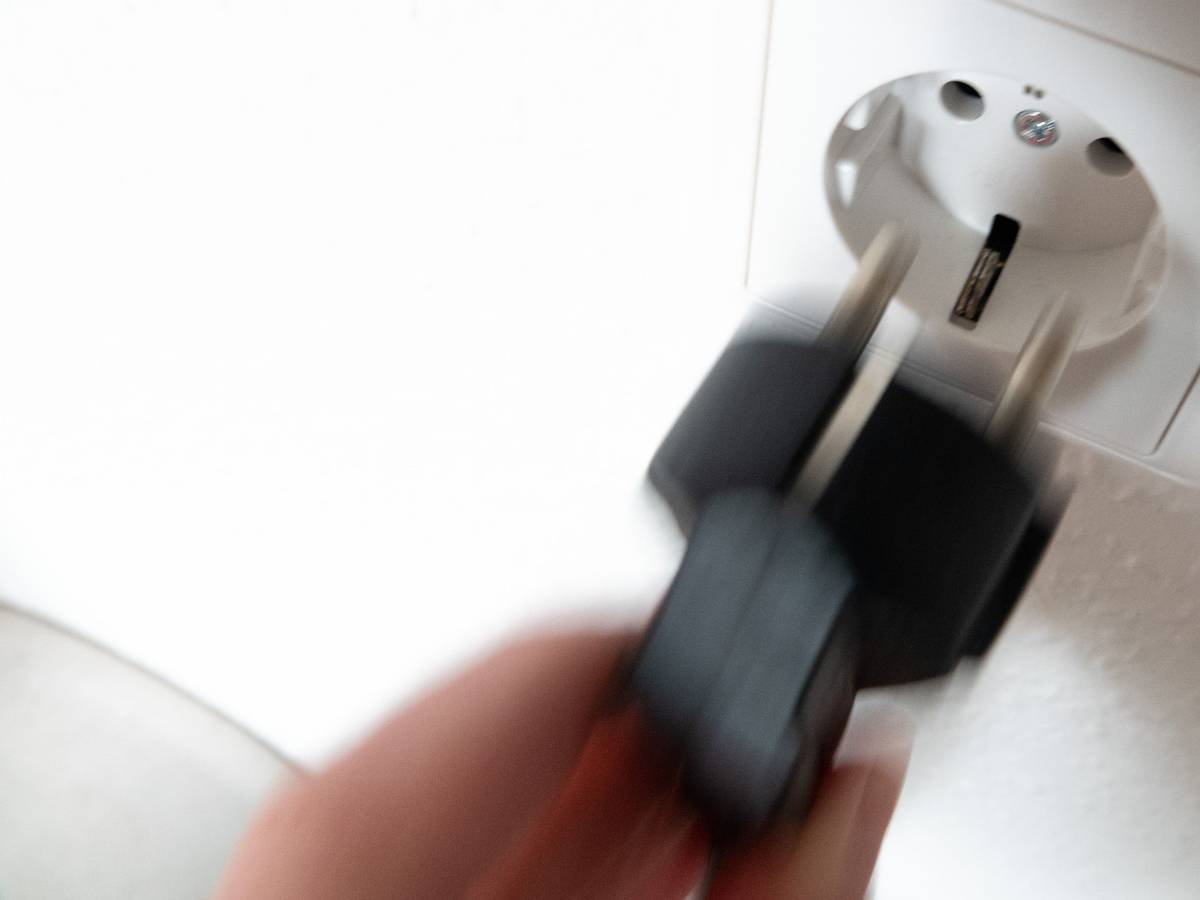 Ein Stecker wird in eine Steckdose gesteckt.