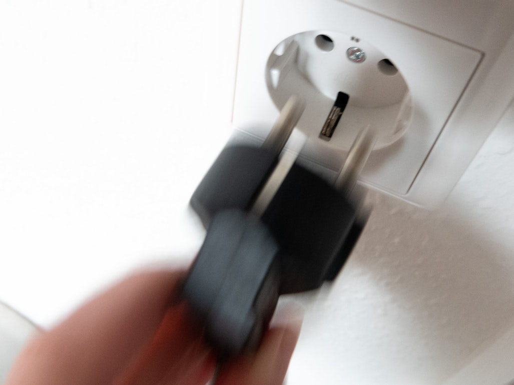 Ein Stecker wird in eine Steckdose gesteckt.