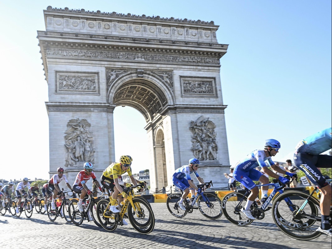 Radfahr-Profis fahren während der Tour de France am Arc de Triomphe in Paris vorbei.
