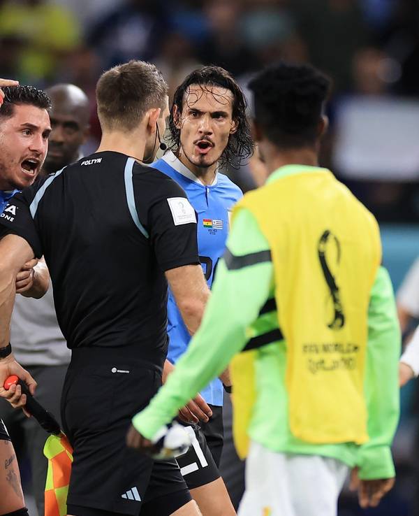 Nationalspieler Uruguays umzingeln den deutschen Schiedsrichter Daniel Siebert nach dem WM-Gruppenspiel gegen Ghana (2:0).