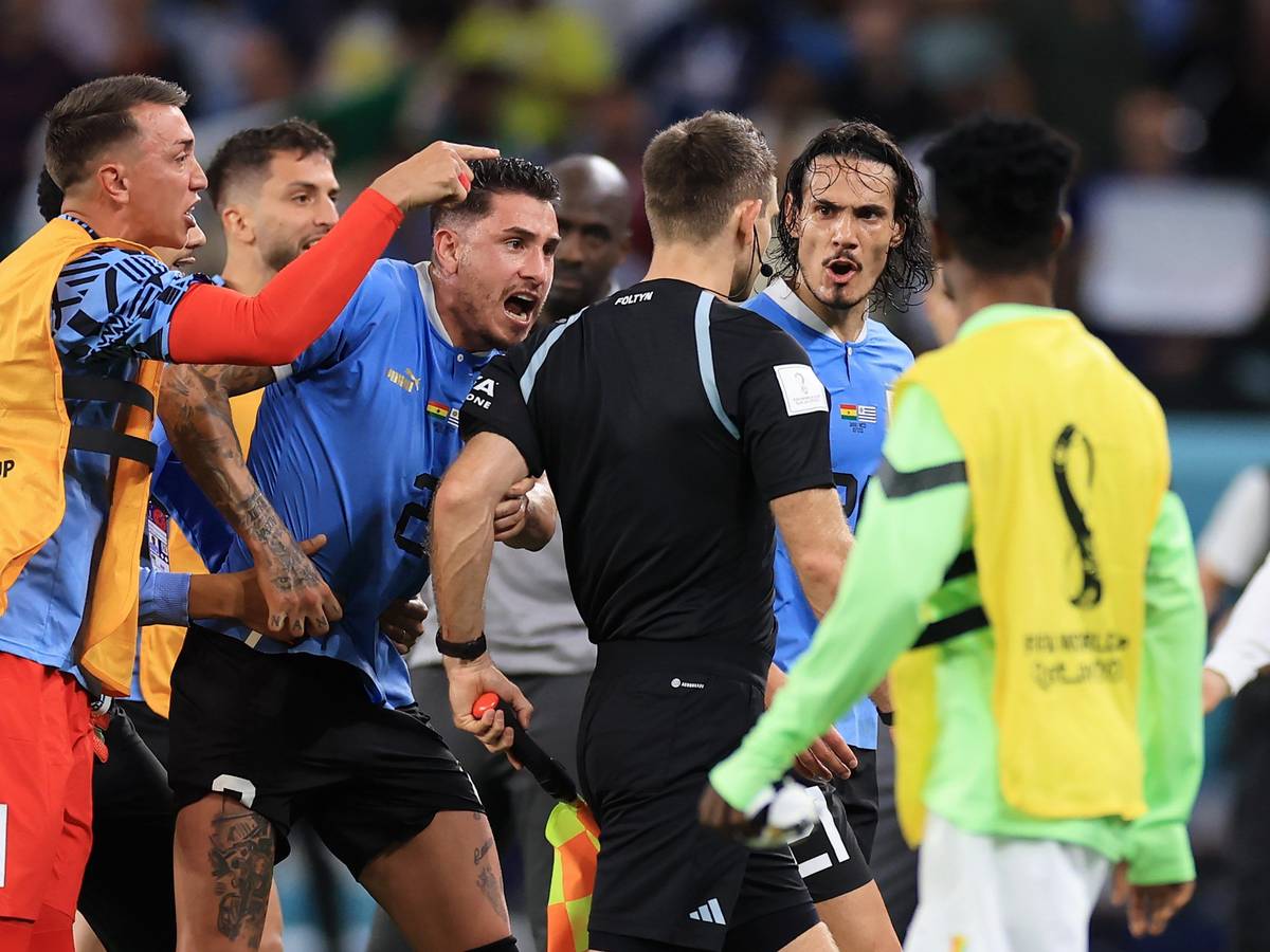 Nationalspieler Uruguays umzingeln den deutschen Schiedsrichter Daniel Siebert nach dem WM-Gruppenspiel gegen Ghana (2:0).