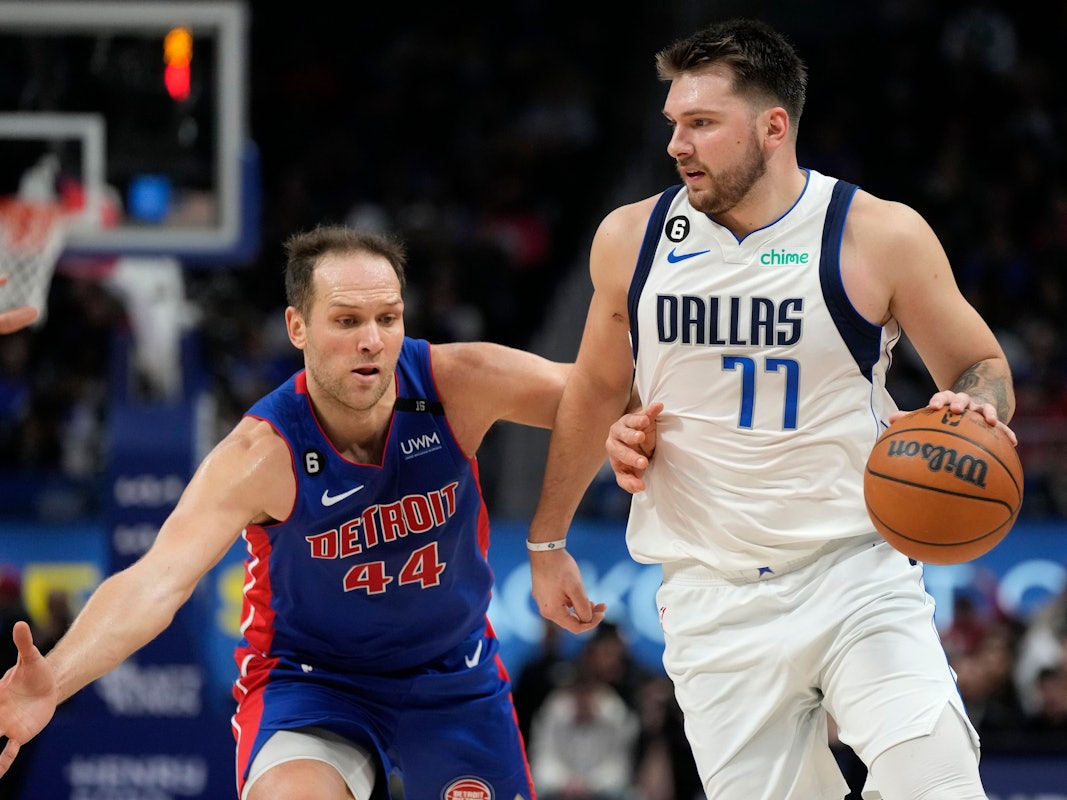 Mavericks-Star Luka Doncic läuft mit dem Ball, Pistons Bojan Bogdanovic versucht ihn daran zu hindern.