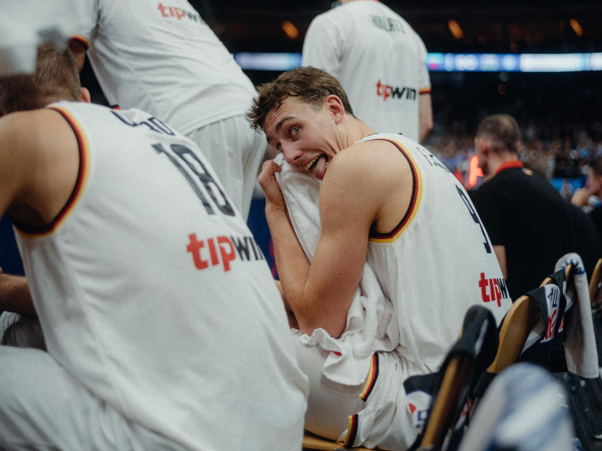 NBA-Profi Franz Wagner grinst beim EM-Spiel um Platz drei in die Kamera von Basti Sevastos.