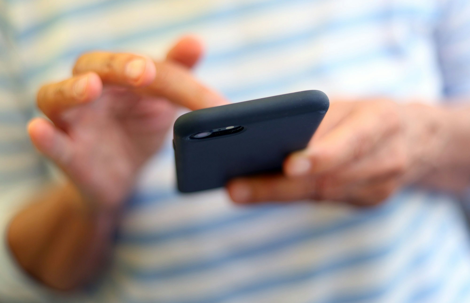 Eine Frau tippt auf einem Smartphone.