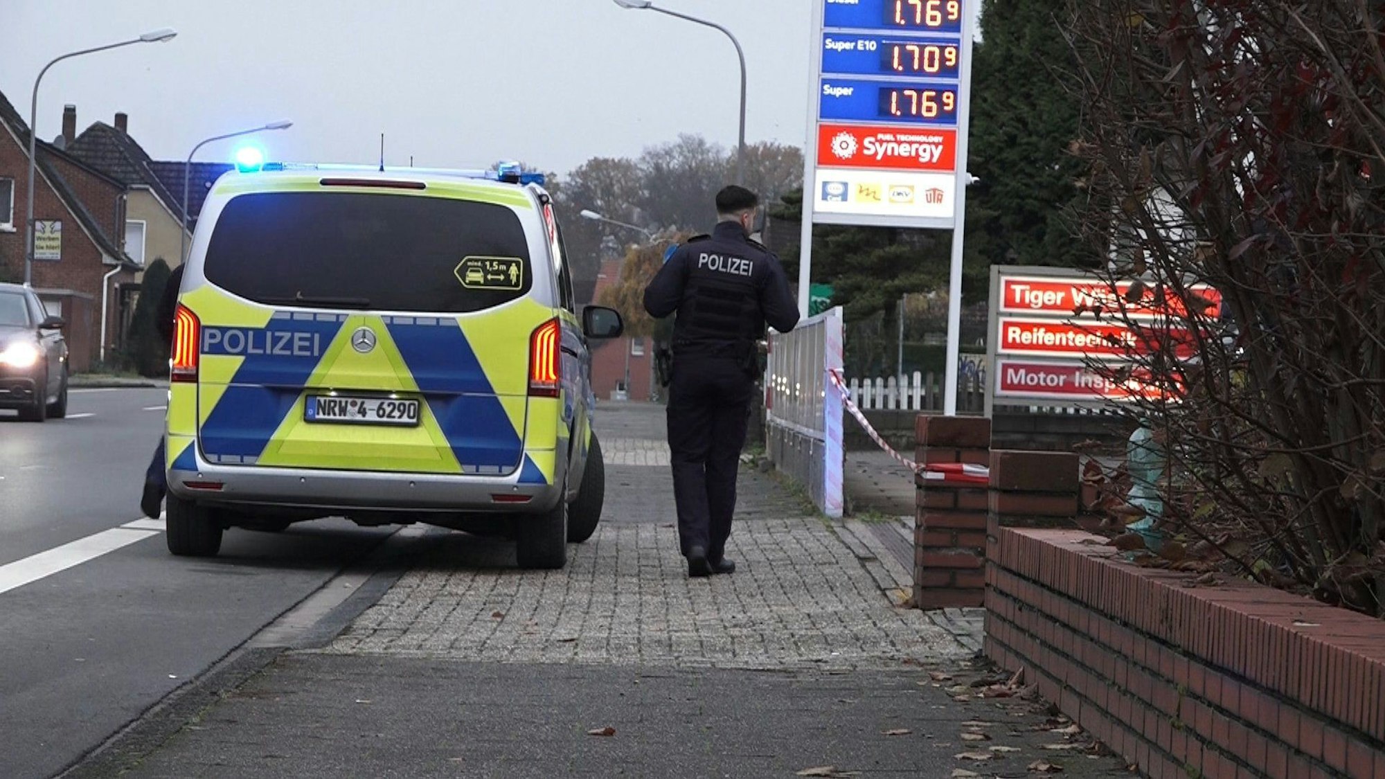 Ein Polizeifahrzeug steht vor einer Tankstelle.