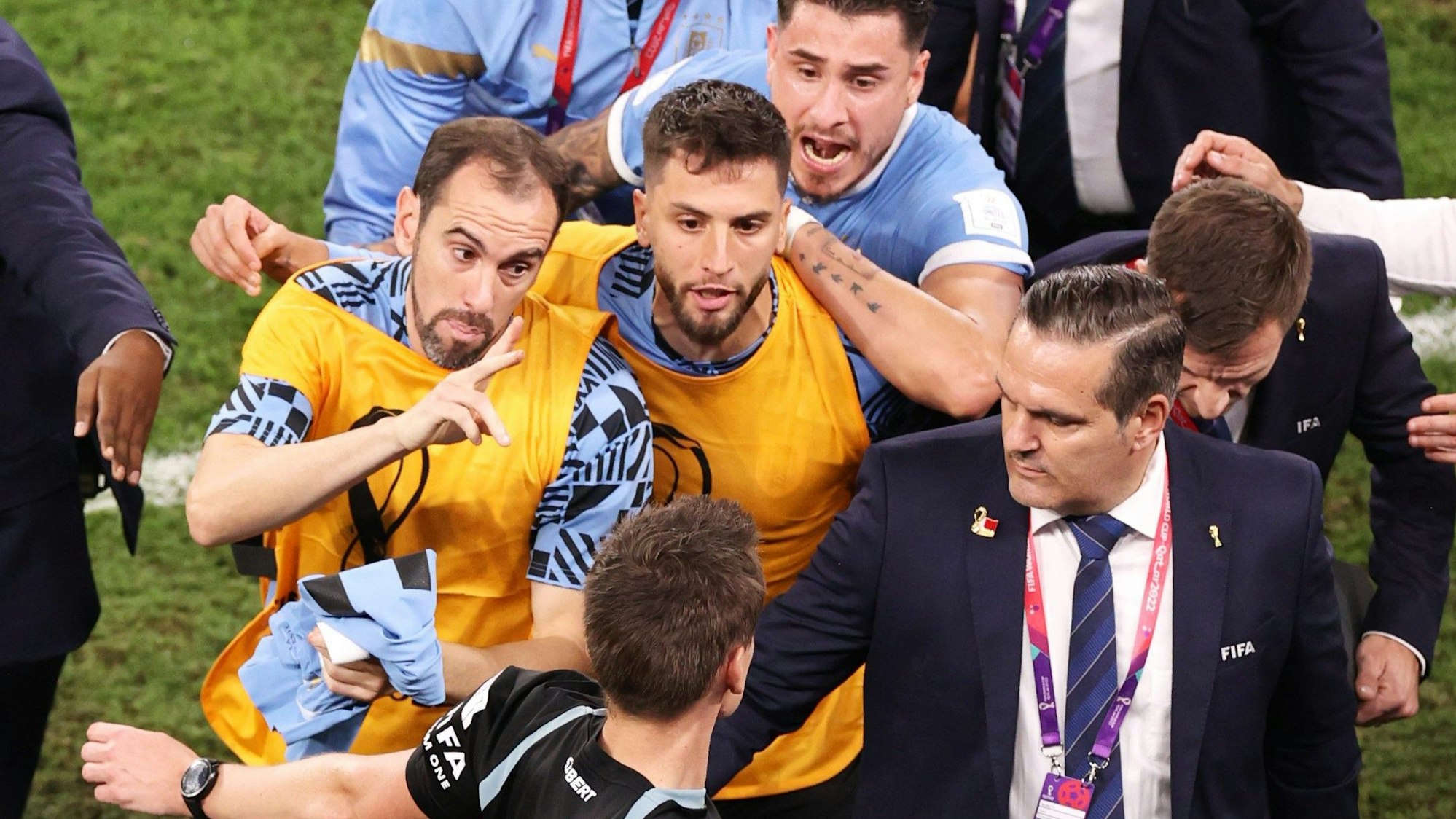 Schiedsrichter Daniel Siebert (unten) wird nach dem WM-Spiel zwischen Uruguay und Ghana von mehreren Spielern der ausgeschiedenen Südamerikaner belagert.