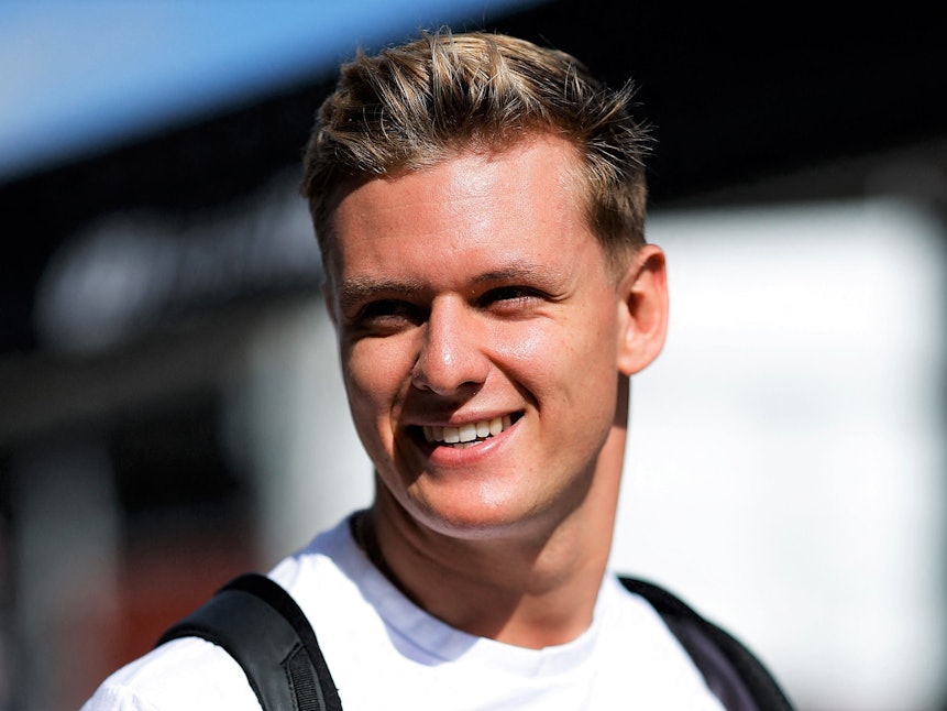 Mick Schumacher geht am Rande des USA-Rennens der Formel 1 in Austin lächelnd durch das Fahrerlager
