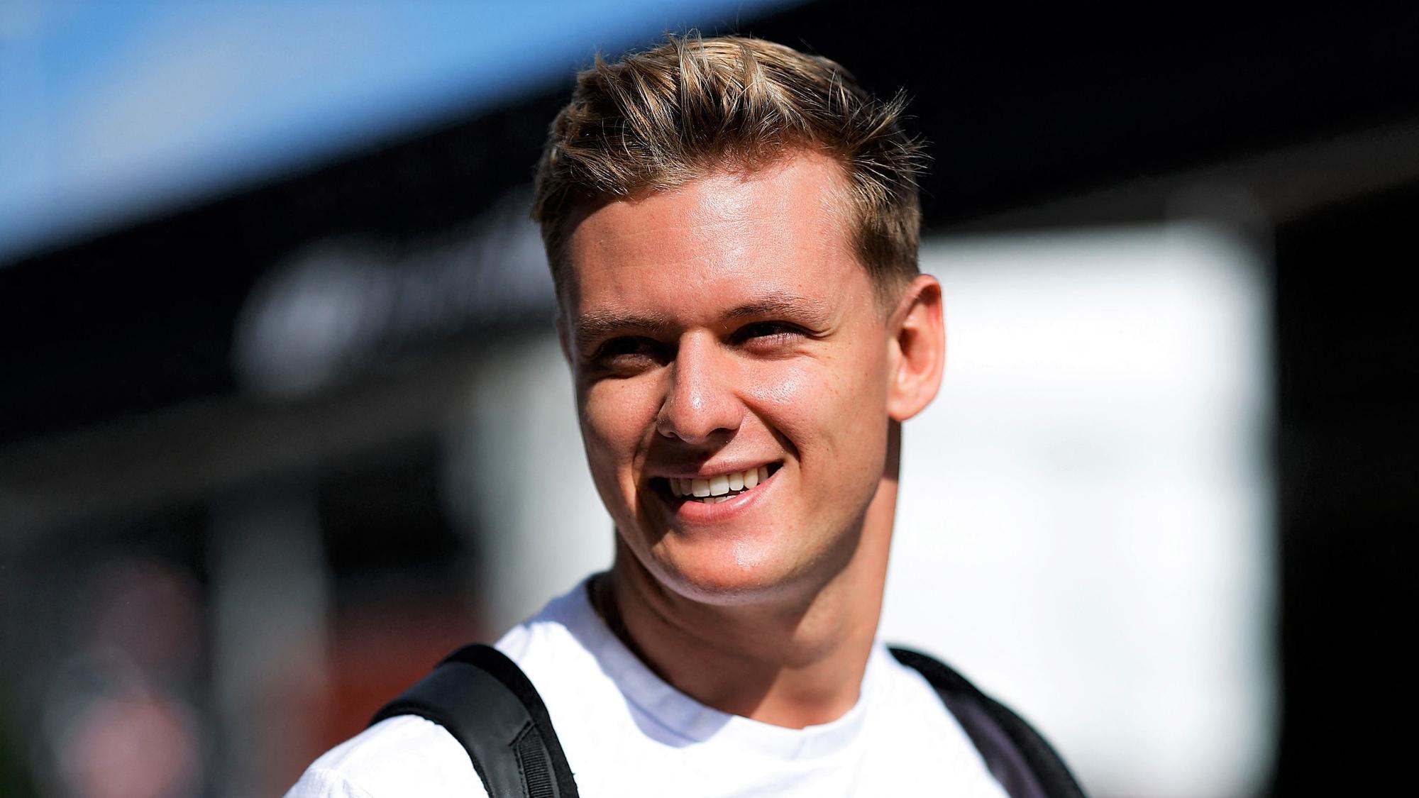 Mick Schumacher geht am Rande des USA-Rennens der Formel 1 in Austin lächelnd durch das Fahrerlager