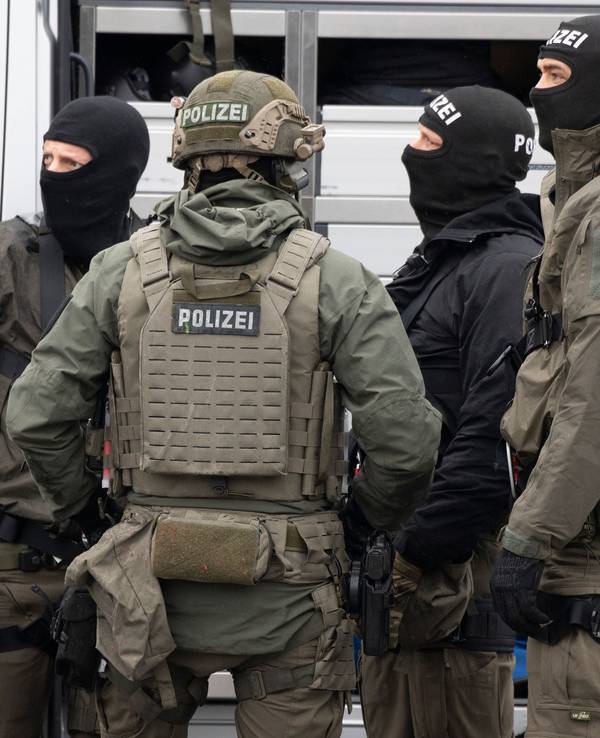Mitglieder des SEK der Polizei stehen vor einem Einsatzfahrzeug und beraten sich.