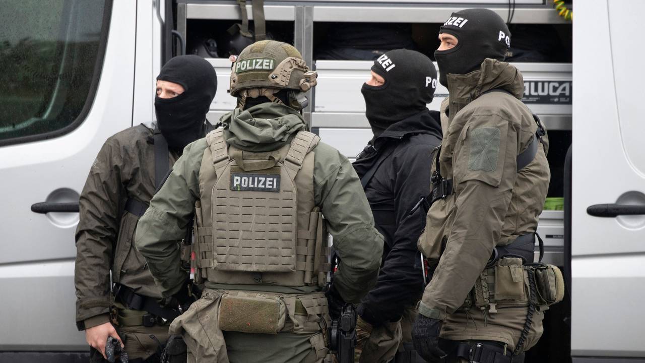 Mitglieder des SEK der Polizei stehen vor einem Einsatzfahrzeug und beraten sich.