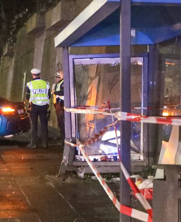 Einsatzkräfte der Polizei ermitteln an einer Bushaltestelle.