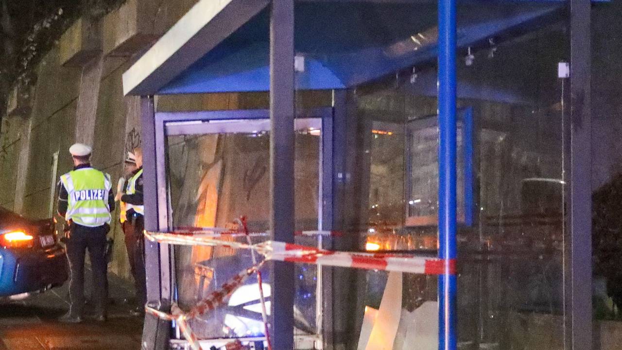 Einsatzkräfte der Polizei ermitteln an einer Bushaltestelle.