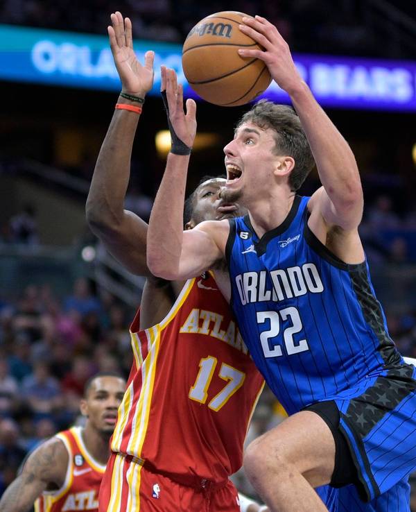 Franz Wagner steigt mit dem Basketball in der Hand zum Korb hoch. Gegenspieler Onyeka Okongwu von den Atlanta Hawks versucht, ihn im NBA-Spiel zu stoppen.