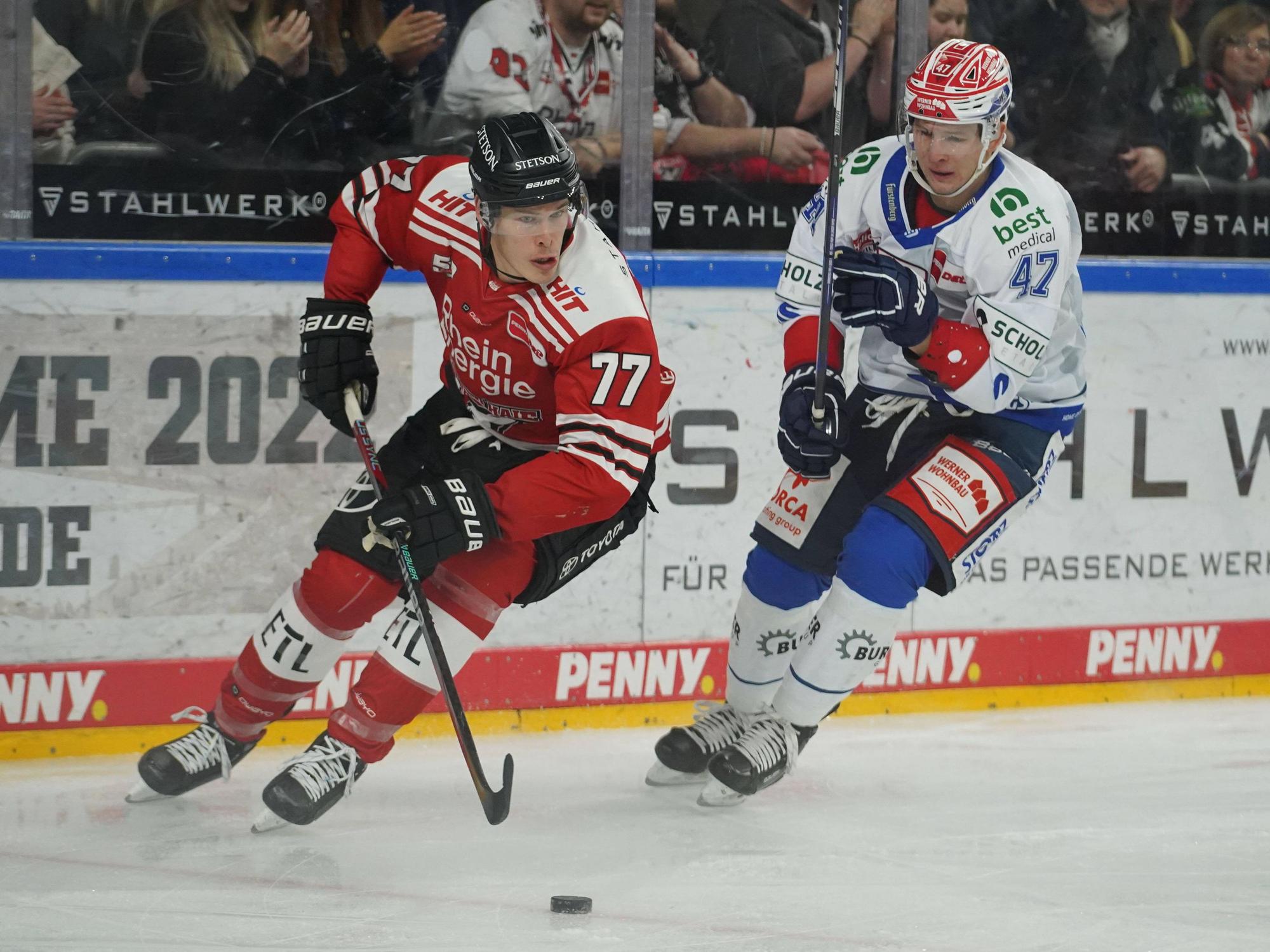 Kölns Alex Roach Köln führt den Puck, Schwenningens Alexander Karachun setzt nach.