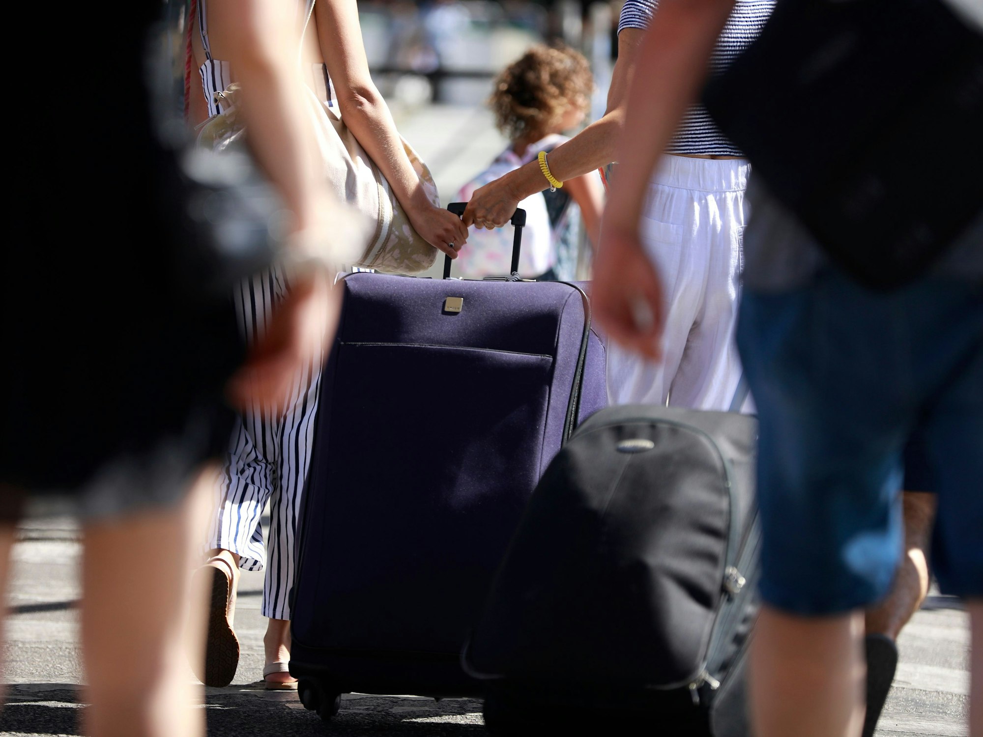 Menschen mit Koffern stehen am Flughafen Palma de Mallorca.