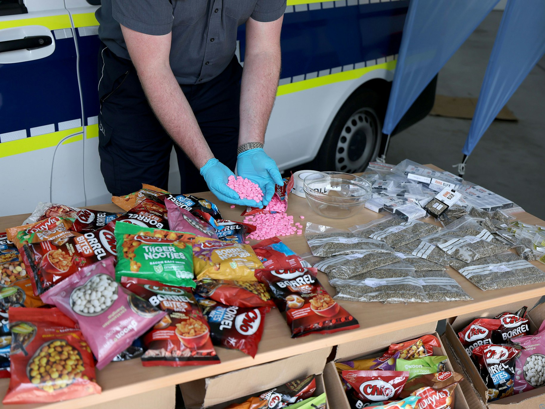 Ein Zollbeamter hält Ecstasy Tabletten in der Hand, die bei Frachtkontrollen in der Nacht des 11. Mai 2021 am Flughafen Köln/Bonn sichergestellt wurden.