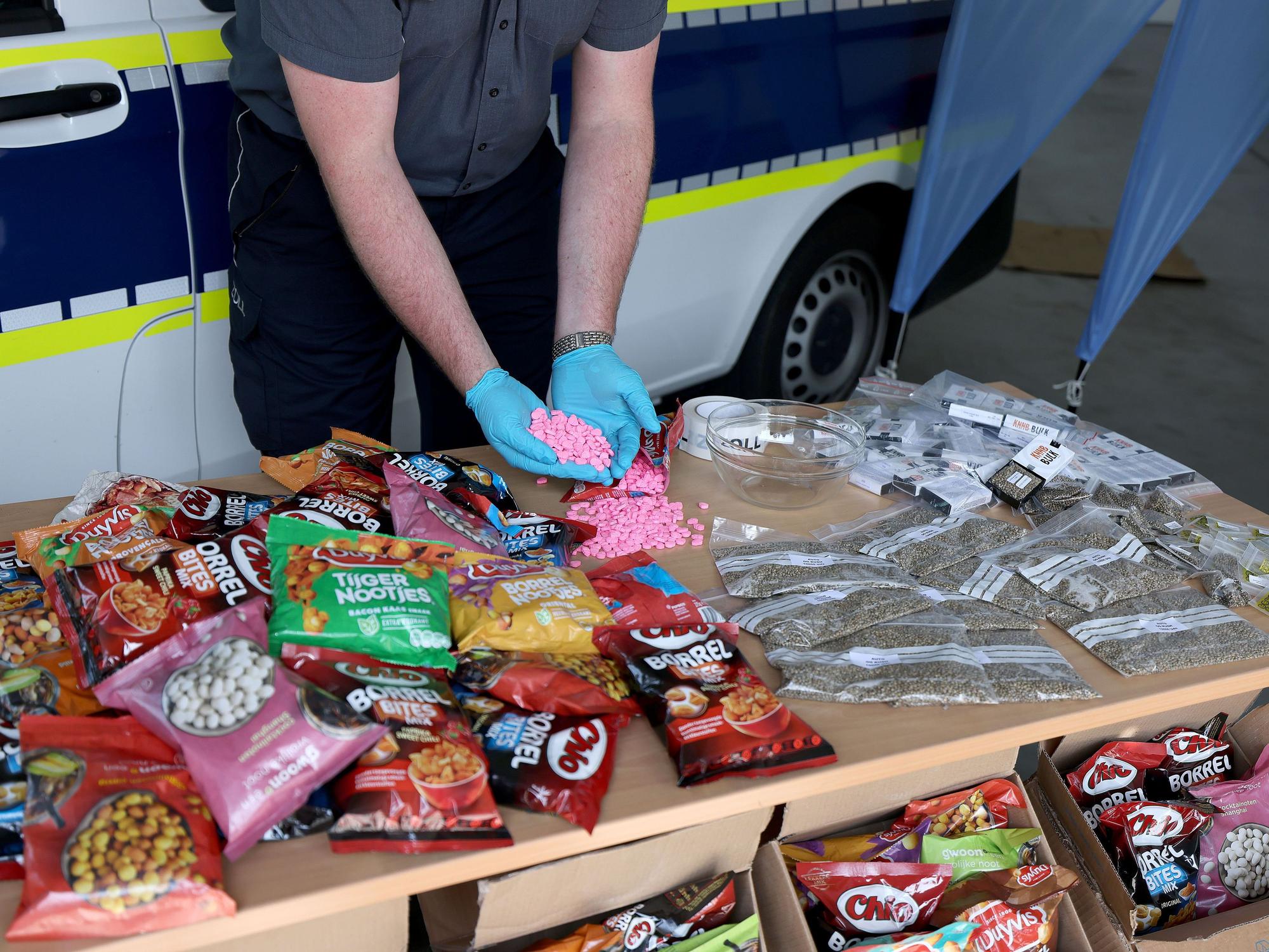Ein Zollbeamter hält Ecstasy Tabletten in der Hand, die bei Frachtkontrollen in der Nacht des 11. Mai 2021 am Flughafen Köln/Bonn sichergestellt wurden.