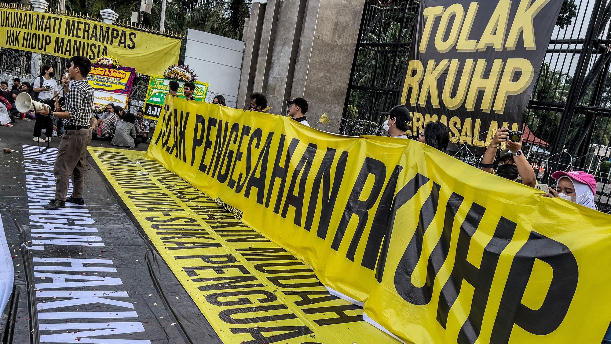 Das Foto zeigt eine indonesische Protestaktion mit gelb-schwarzen Bannern und vielen Menschen.