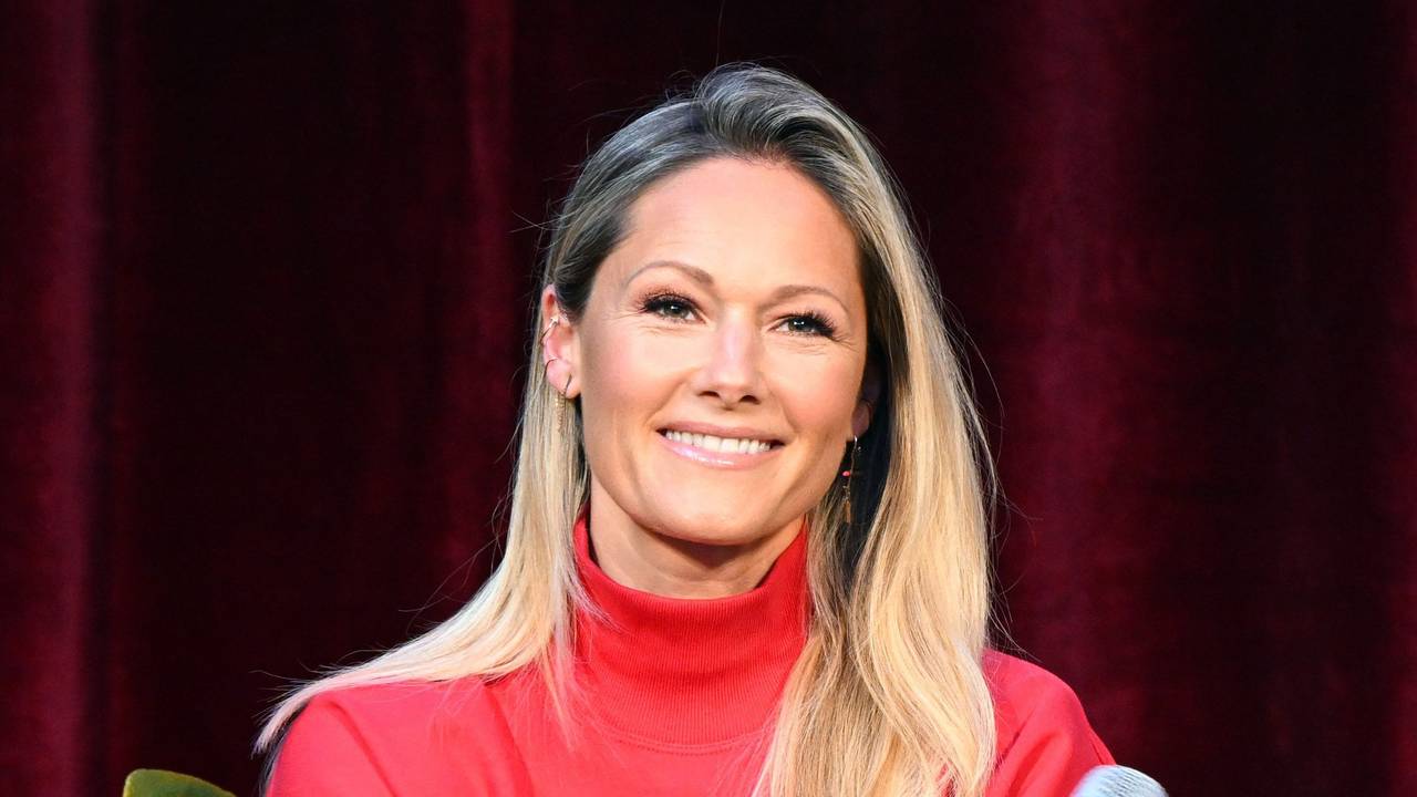 Helene Fischer steht bei einem Pressetermin Journalistinnen und Journalisten Rede und Antwort. Die Sängerin trägt einen roten Pullover und hält ein Mikrofon in der Hand.