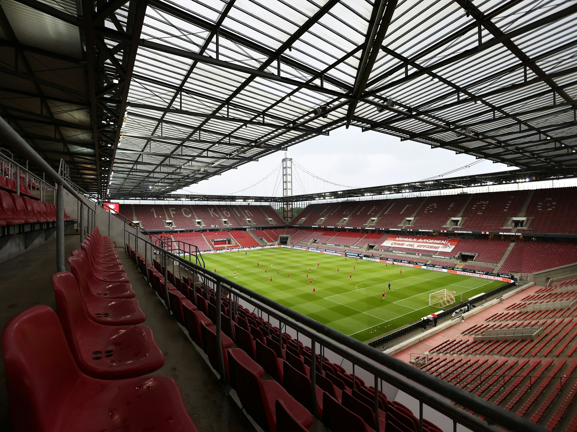 Foto von der obersten Tribüne in das Innere des Rhein-Energie-Stadions in Köln. Auf dem Rasen spielen Menschen Fußball.