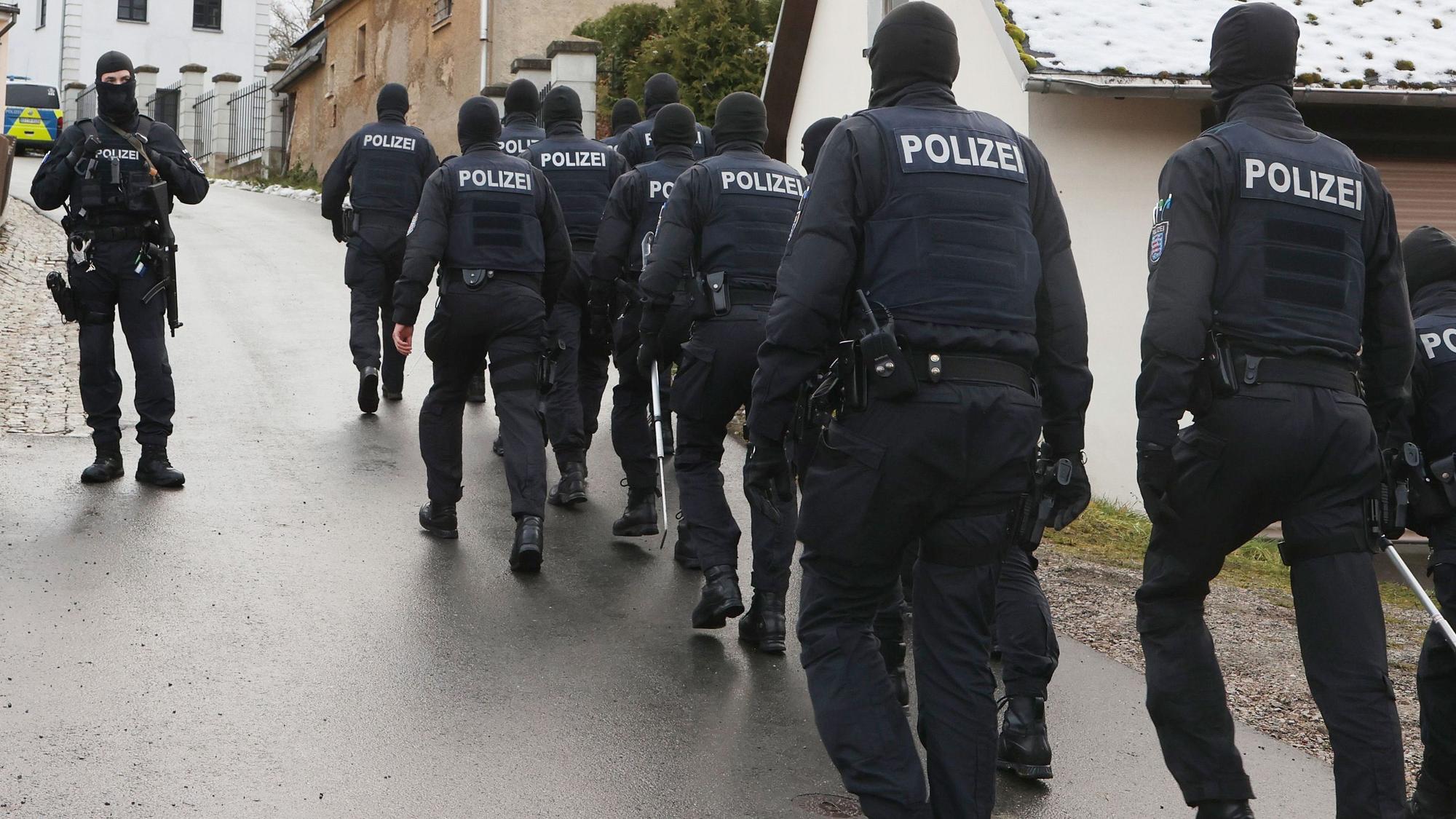 Einsatzkräfte der Polizei laufen zum Jagdschloss Waidmannsheil, während der Durchsuchung durch die Polizei.