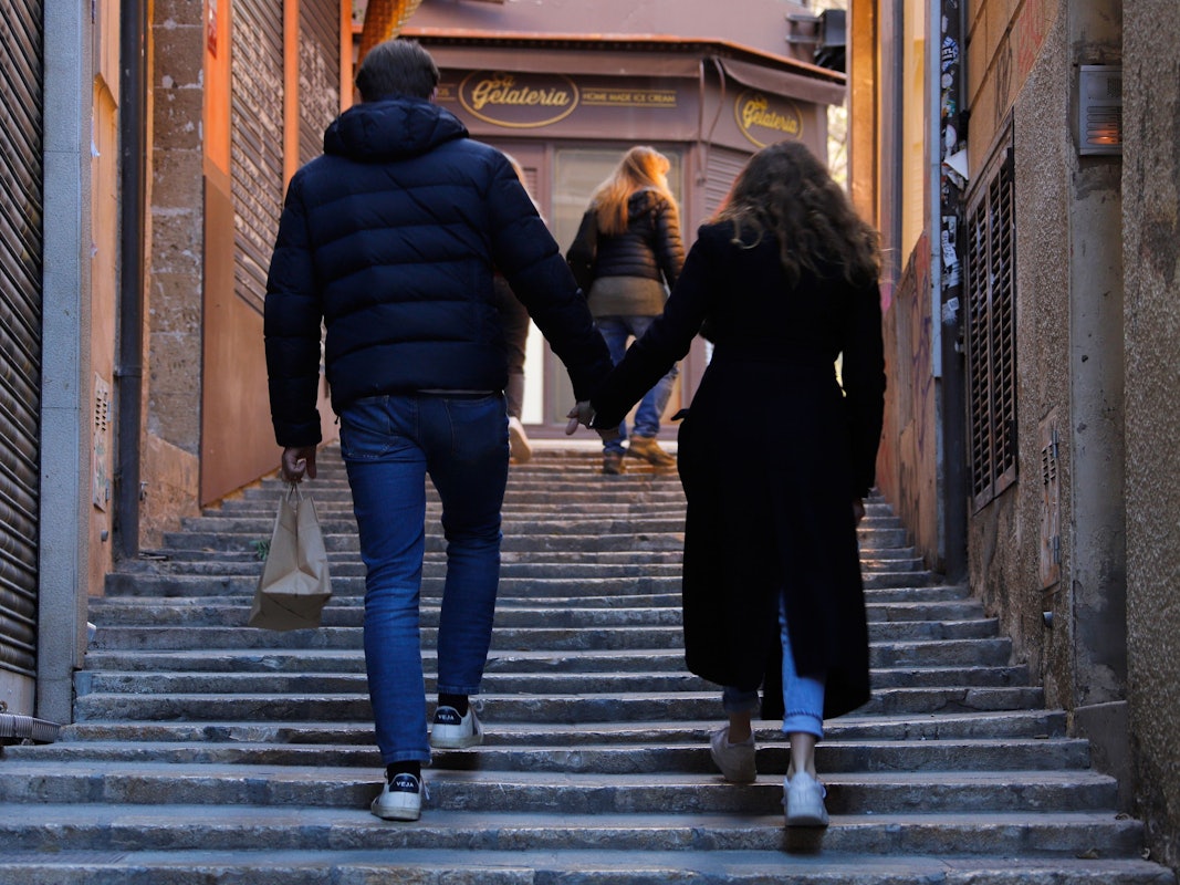 Ein Paar geht an geschlossenen Läden in der Innenstadt von Palma de Mallorca vorbei.