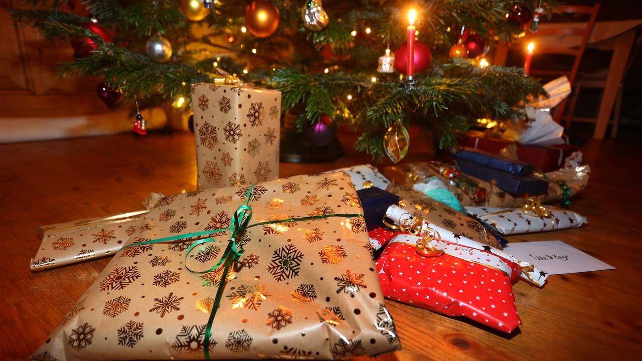 Verpackte Geschenke liegen unter einem festlich geschmücktem Weihnachtsbaum.