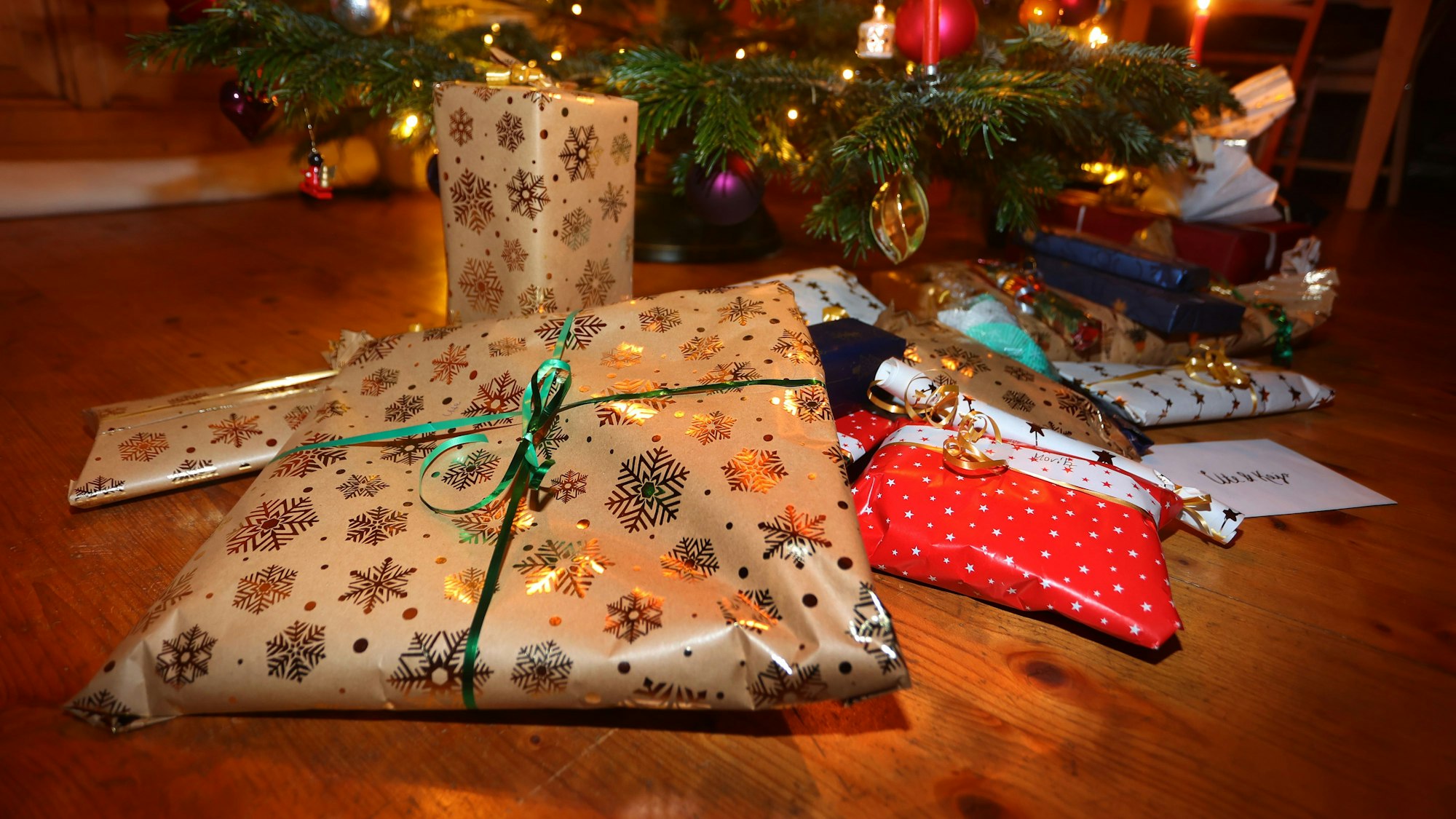 Verpackte Geschenke liegen unter einem festlich geschmücktem Weihnachtsbaum.