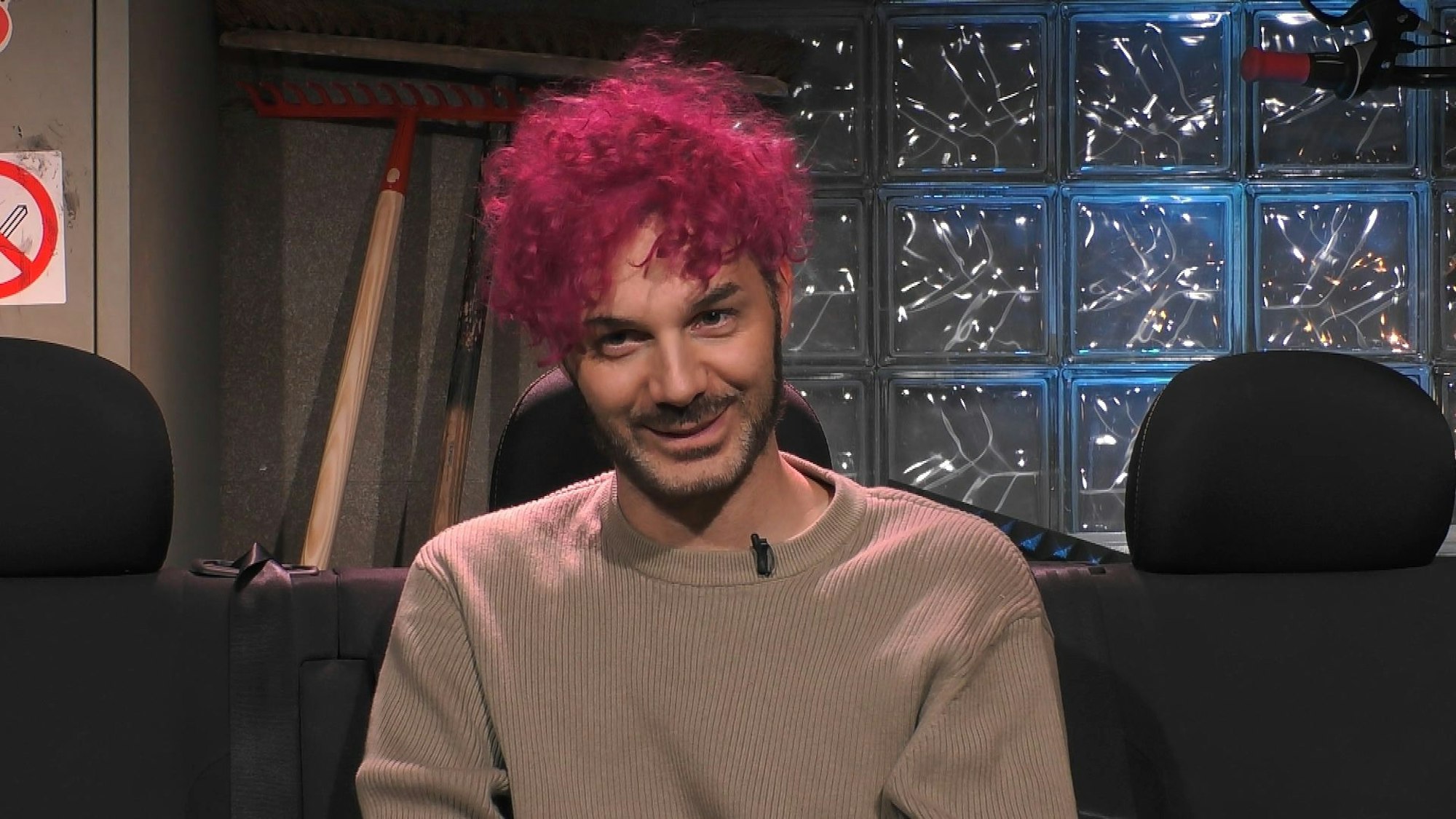 Sam Dylan lächelt im „Promi Big Brother“-Sprechzimmer.