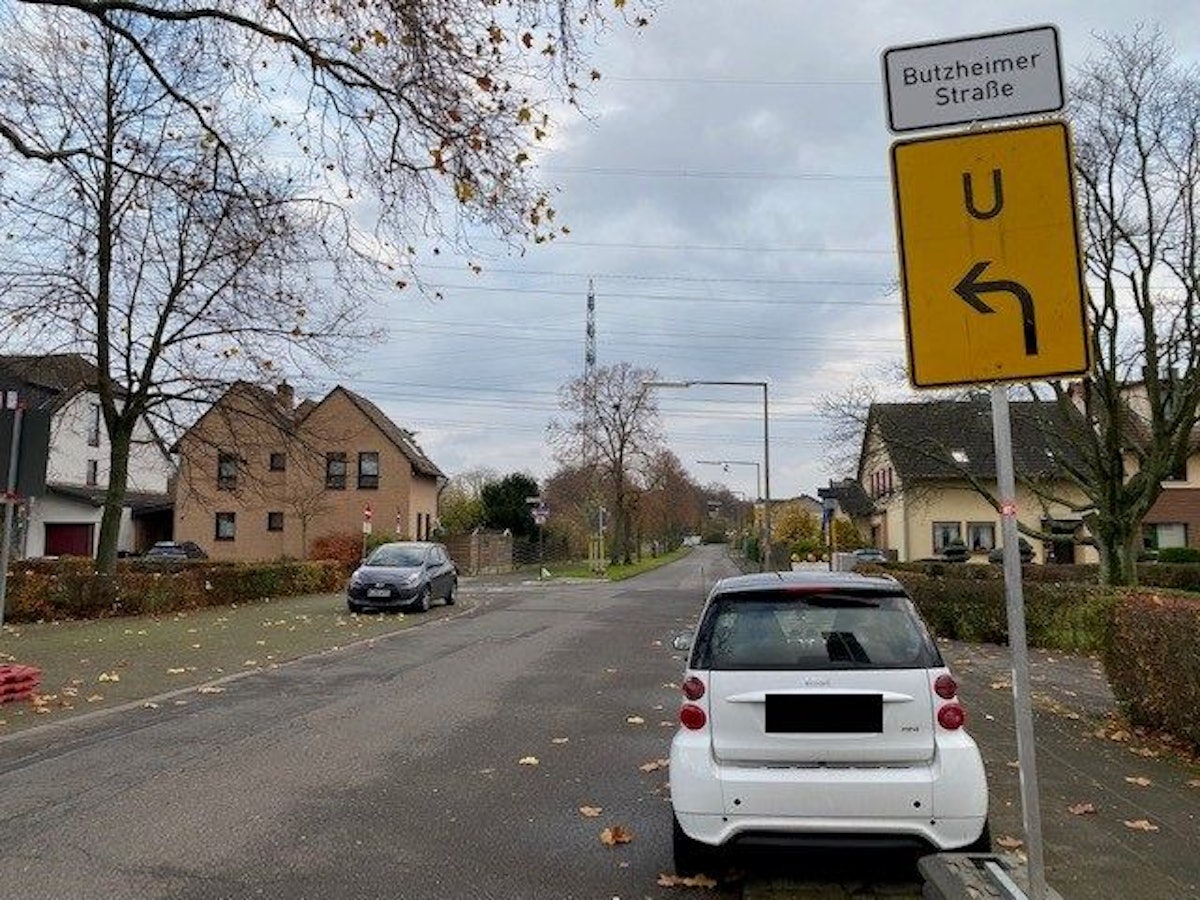 Ein Smart steht an einer Straße vor einem Schild, das auf eine Umleitung hindeutet.