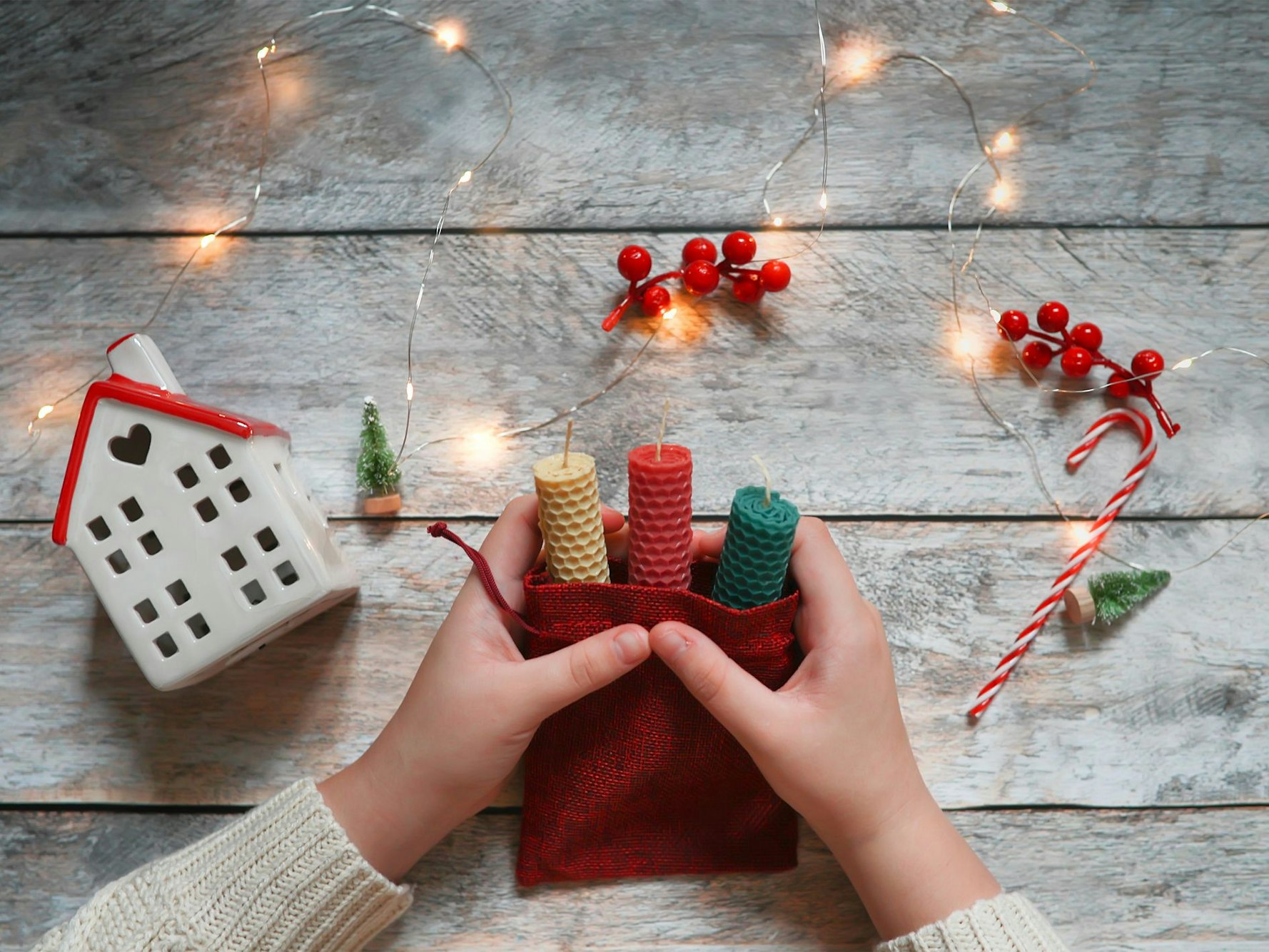 Kinderhände beim Einpacken von Geschenken. 2022 sind zu Weihnachten Selbstgemachtes und Nachhaltiges angesagt.