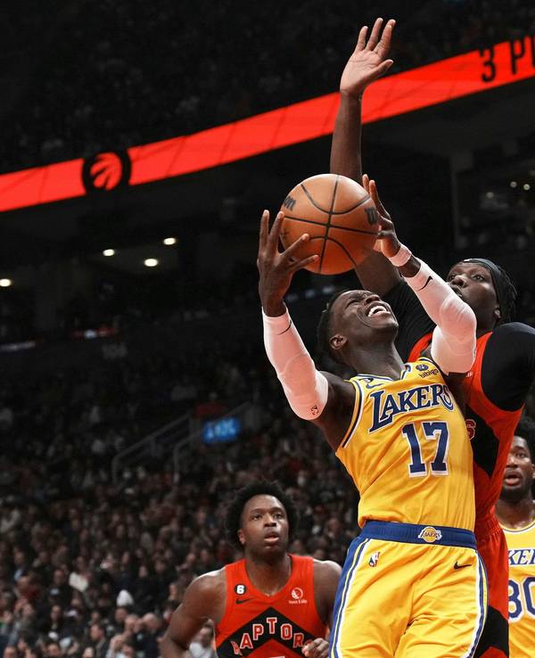 Dennis Schröder im gelben Trikot der Los Angeles Lakers geht zum Korb, während Chris Boucher von den Toronto Raptors verteidigt.