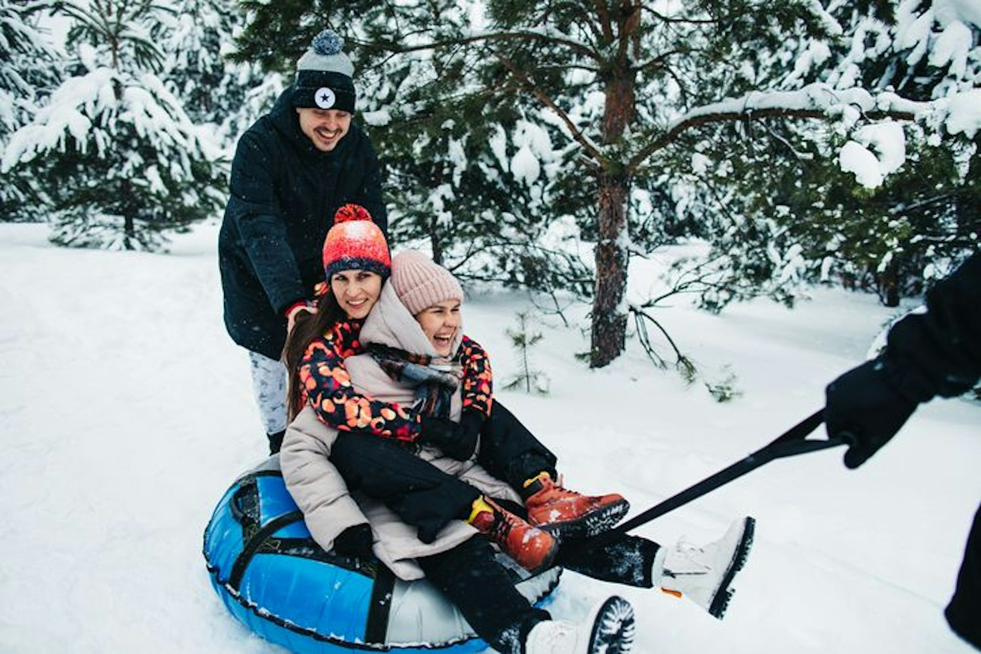 Friends ride tubing in the snow in winter