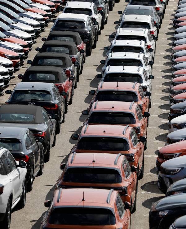 Das Symbolfoto zeigt verschiedenfarbige Mietwagen, die auf einem großen Parkplatz aufgereiht sind.