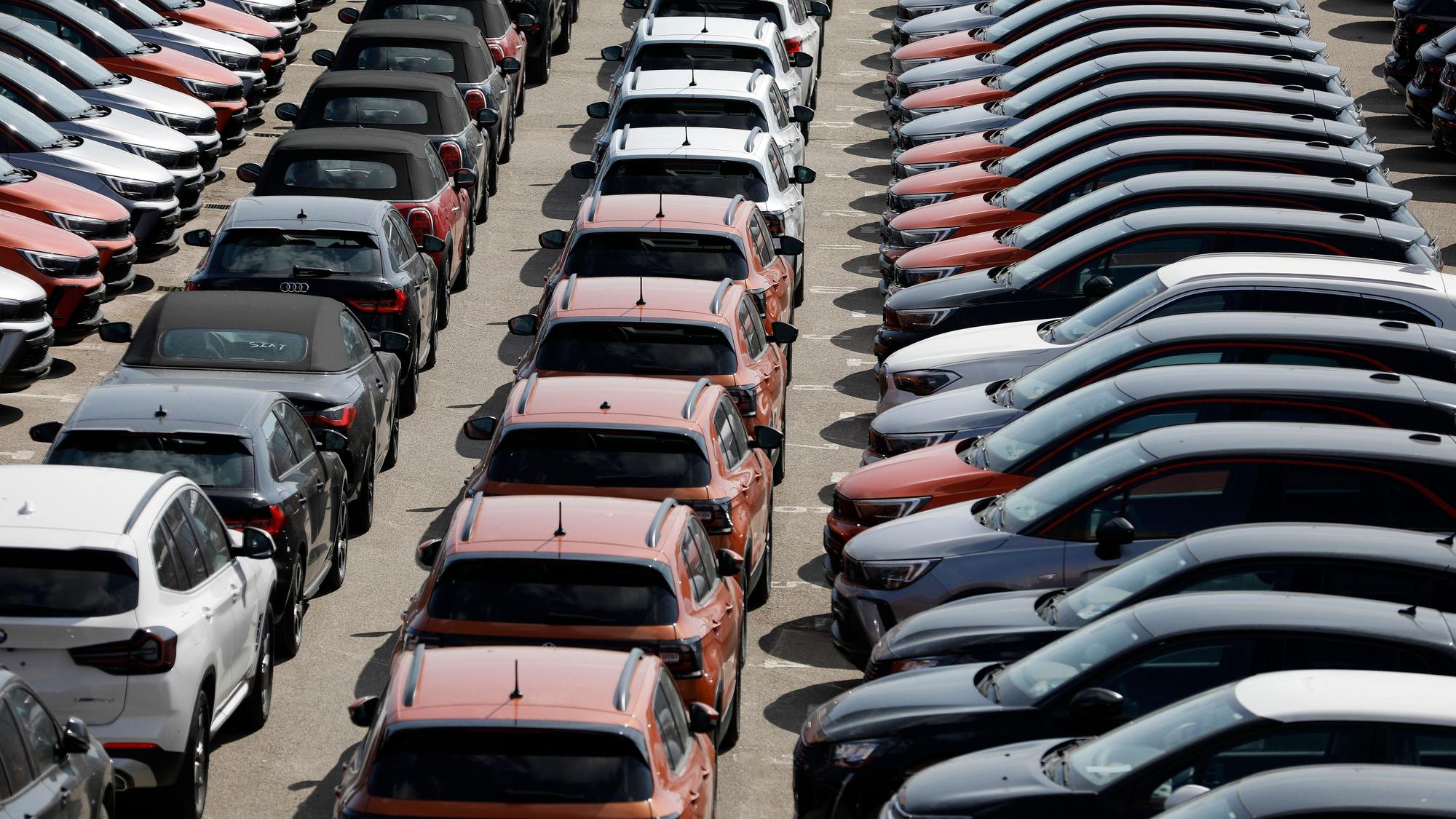 Das Symbolfoto zeigt verschiedenfarbige Mietwagen, die auf einem großen Parkplatz aufgereiht sind.