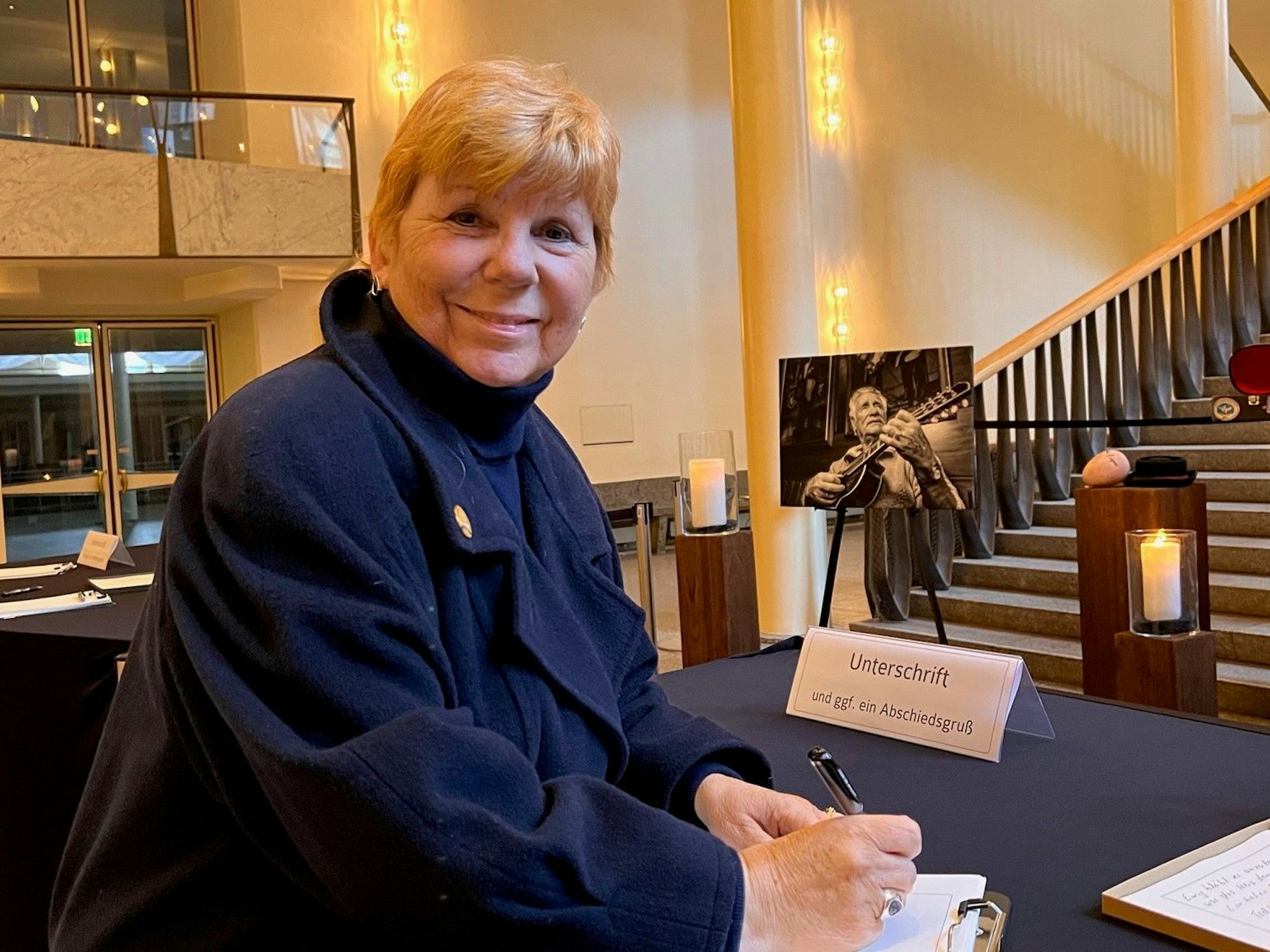 Eva Ladwig (68) trägt sich in das Kondolenzbuch für Hans Süper im Kölner Gürzenich ein.