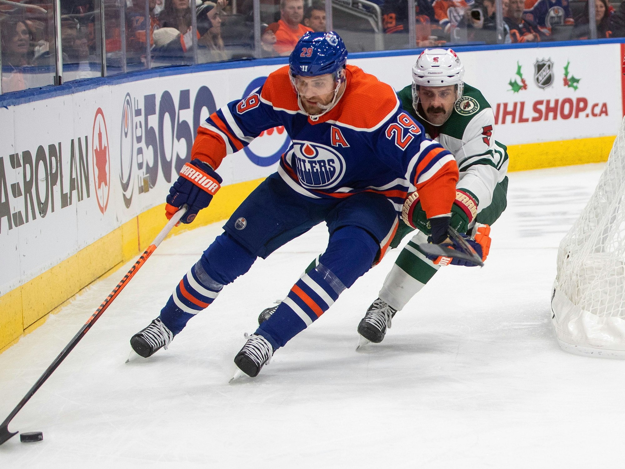Jacob Middleton (Minnesota Wild) und Leon Draisaitl (Edmonton Oilers) kämpfen in der NHL um den Puck.