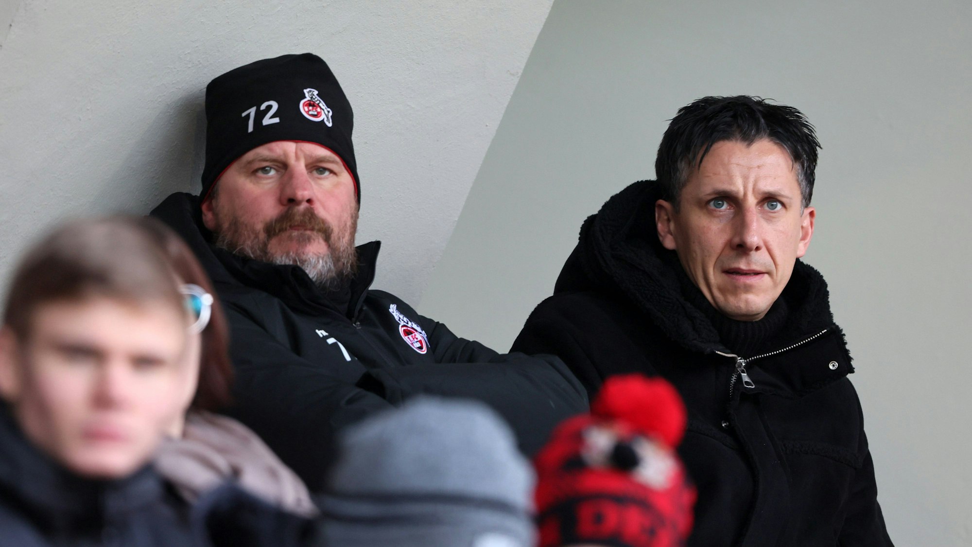 Steffen Baumgart und Christian Keller sitzen nebeneinander auf der Tribüne im Franz-Kremer-Stadion.