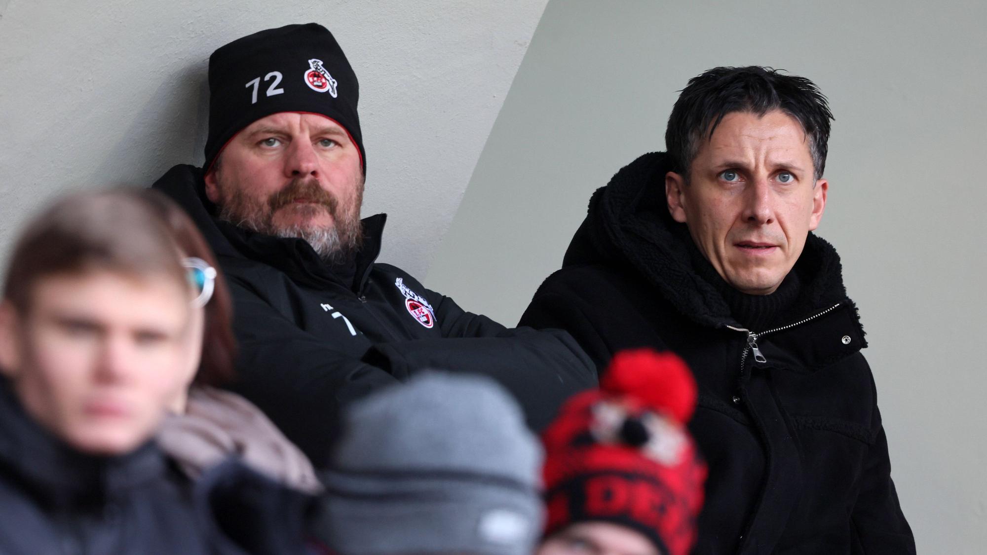 Steffen Baumgart und Christian Keller verfolgen das Frauen-Bundesligaspiel des 1. FC Köln gegen den SC Freiburg im Franz-Kremer-Stadion an.