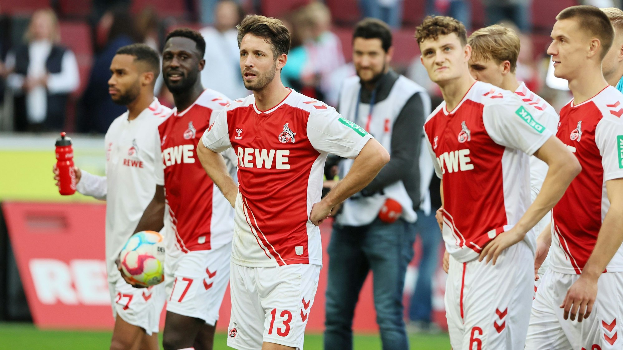 Mark Uth und die Profis des 1. FC Köln stehen nach dem Heim-Sieg gegen den FC Augsburg vor der Südkurve.