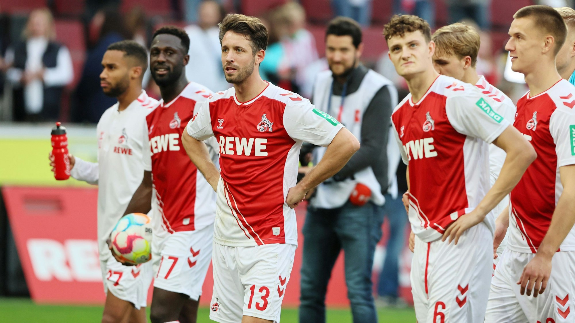 Mark Uth und die Profis des 1. FC Köln stehen nach dem Heim-Sieg gegen den FC Augsburg vor der Südkurve.