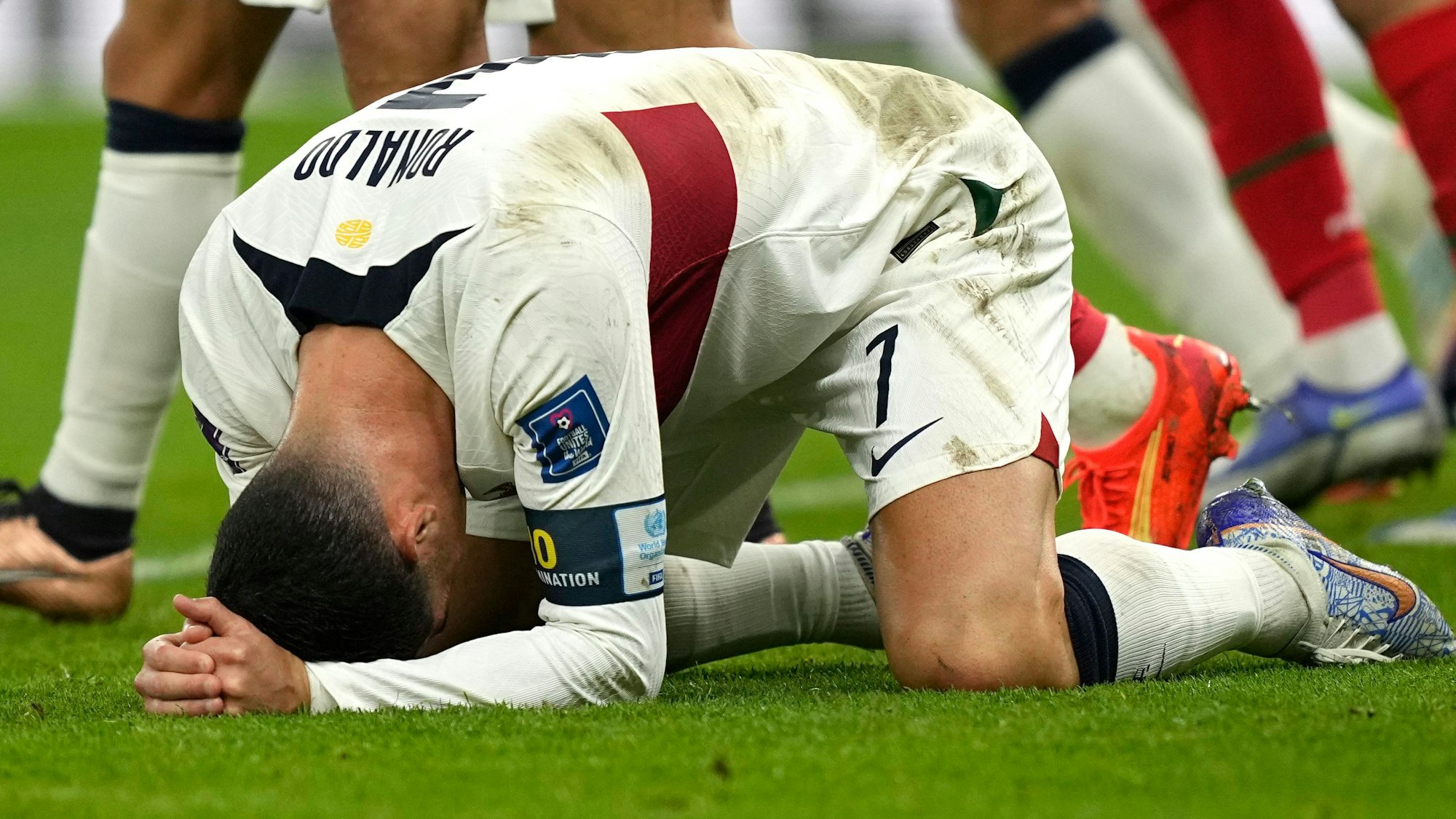 Cristiano Ronaldo hockt auf dem Rasen und hält sich enttäuscht den Kopf.