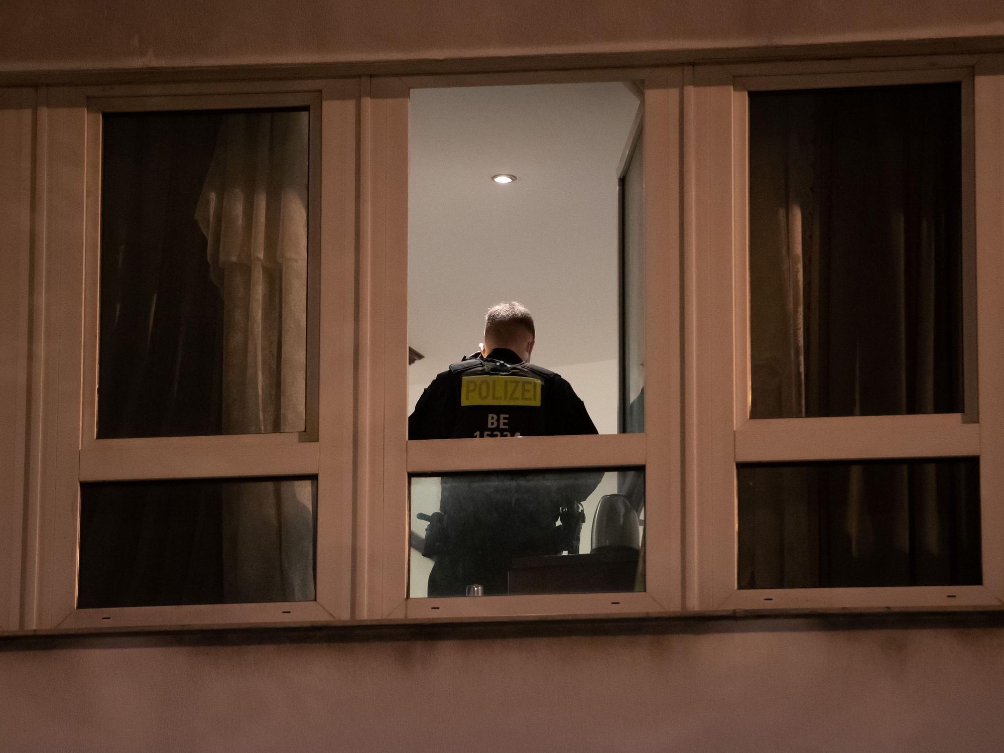 Ein Polizist steht in einem Zimmer eines Hotels und durchsucht es.