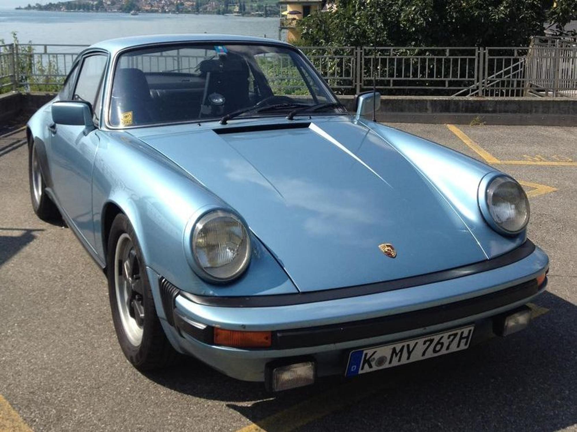 Ein blauer Porsche steht auf einem Parkplatz.