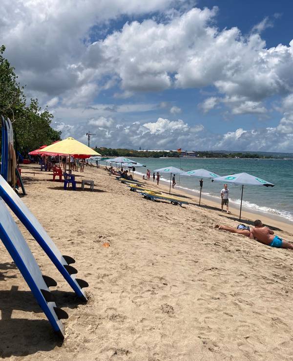 Surfbretter und Sonnenschirme stehen am Strand auf Bali.